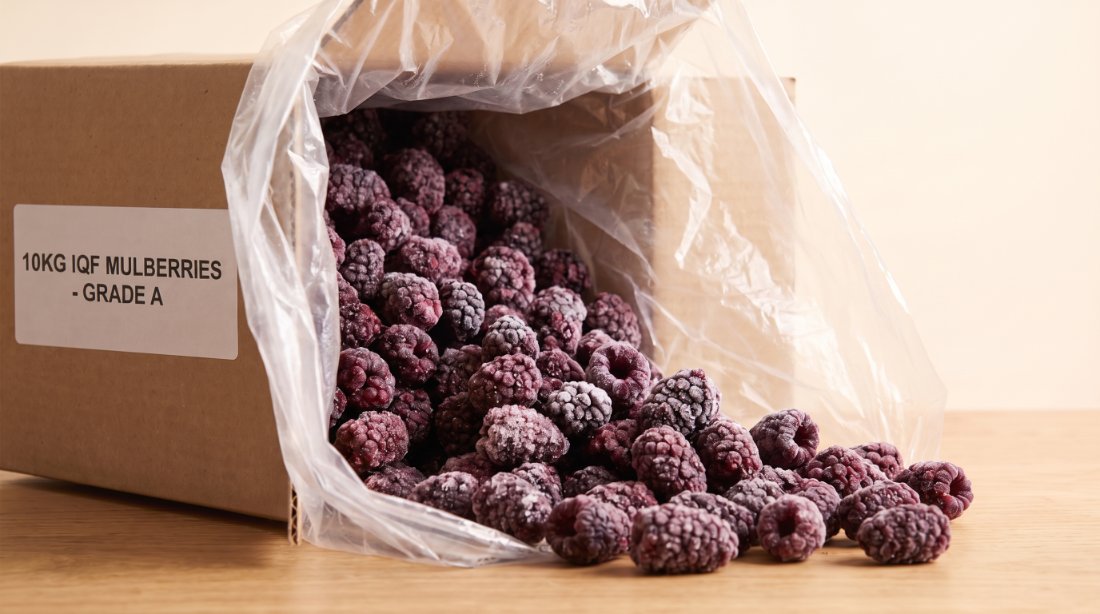 10 kg box of individually frozen organic mulberries, loose free-flow fruit spilling from the liner